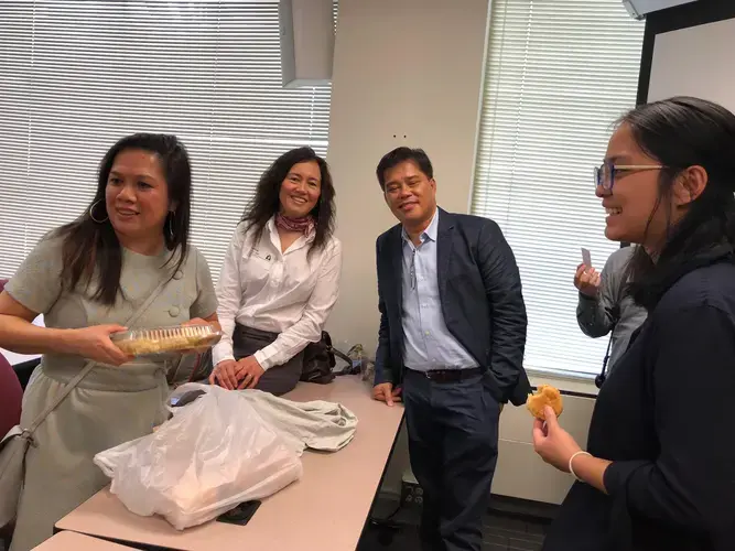 After the panel discussion, Wilma Consul (left) shares hopia, a Philippine pastry, with Cheryl Diaz Meyer and panelists Carlos Conde and Pat Nabong. Image by Kem Knapp Sawyer. United States, 2018.
