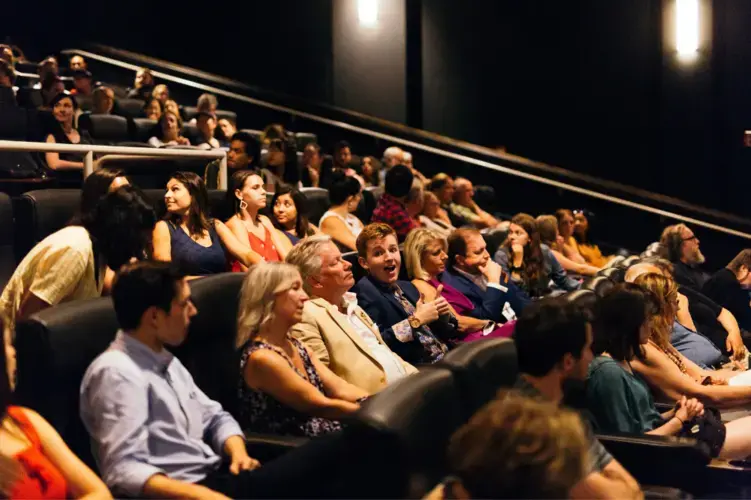 An audience of nearly 200 packed into the Landmark Bethesda Row Theater, watching 'This Little Land of Mines' unfold on screen. Image by Matt Francisco. United States, 2019.