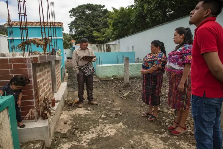 Roberto Primero Luis’s parents, Lucas and Eufemia, with his sister and brother-in-law, Nohelia and Edmer, at his grave in Cubulco, Guatemala. Image by Daniele Volpe/The New York Times. Guatemala, undated.