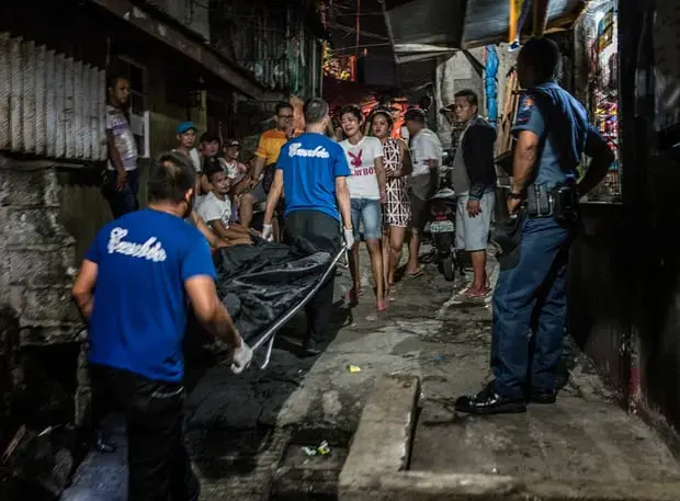 Ginnalyn Soriano, 21 encounters the body of her elder brother, Julius, 24, whose corpse is being carried away in a body bag after he was executed. His body showed signs that his hands were bound before he was shot dead during a police operation in Caloocan, Metro Manila. Image by James Whitlow Delano. Philippines, 2018.