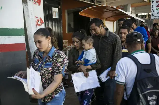 Migrants line up in Tapachula to have their paperwork processed. Image by Jose Cabezas. Mexico, 2018.