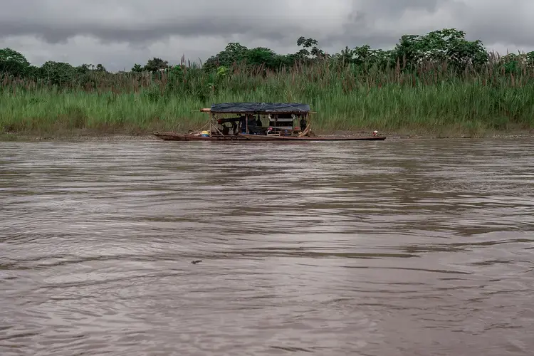 A boat loaded with equipment for illegal gold mining waits in the Marañón River, Amazonas. Image by Marcio Pimenta. Peru, 2019.