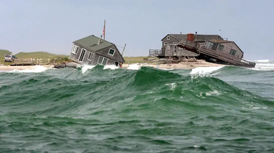 Two of five beach houses on the southern tip of Nauset Beach in Chatham were knocked off their foundations by a 2009 storm. Image by Vincent DeWitt. United States, 2009.