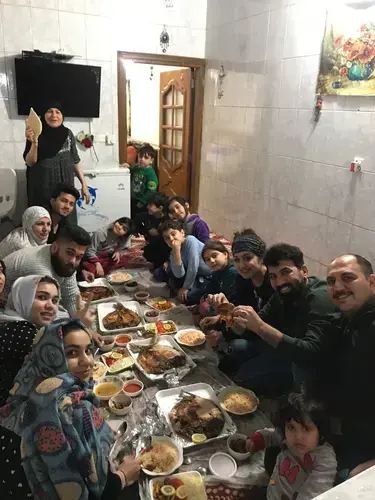 Zahra Ahmad sits with her family eating dinner in Baghdad, Iraq. Image courtesy of Ahmad family.