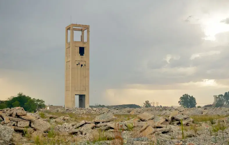 A mine shaft rises from the ruins of a former gold mine outside Welkom. Documents indicate that more than R5-billion is held in mine rehabilitation funds in the Free State, and the operations with the largest 5% of the funds account for 99% of that money. Image by Mark Olalde. South Africa, 2017.