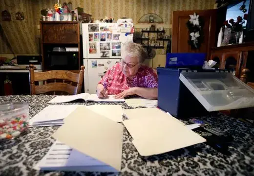 Mary Rieckmann documents farm expenses at her kitchen table while her husband, John, and sons do daily chores around their dairy farm Wednesday. Wisconsin, 2019. Danny Damiani/USA TODAY NETWORK.