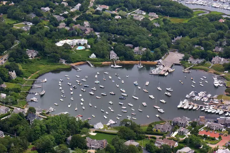 Stately sprawling manses line Harwich Port’s Wychmere Harbor, which is dotted with fishing and pleasure boats. Image by John Tlumacki. United States, 2019.