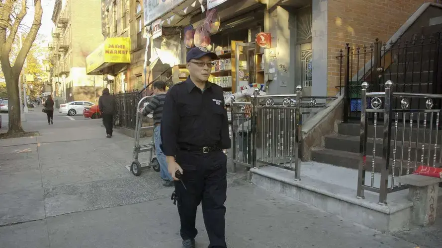 Chen Jihua, an auxillary policeman in New York, patrols in Brooklyn. He didn't see his daughter for 16 years after being smuggled into the U.S. by Chinese snakeheads. Image by Rong Xiaoqing. United States, 2016.