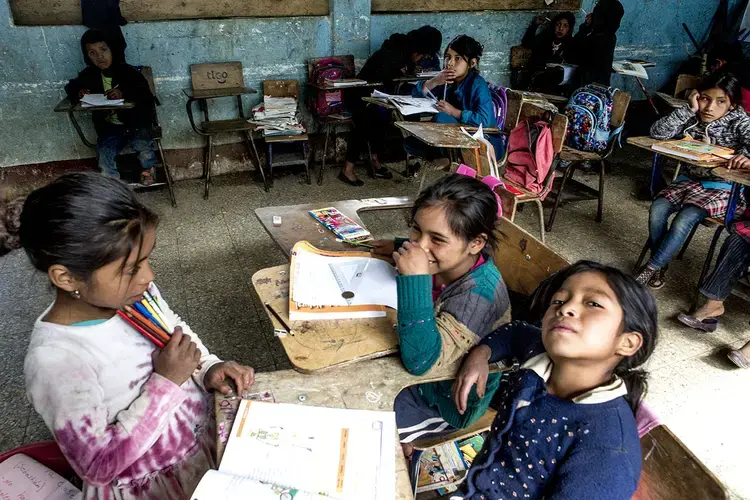 The desk of Baldemar Lucas García Alonzo looks empty at the back of the classroom of the primary school of Bulej. The boy undertook the trip to the United States with his father, the previous week. Image by Simone Dalmasso. Guatemala, 2019.