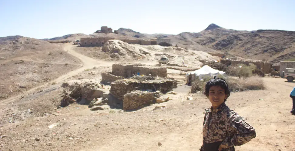 A boy stands in the village of al Ghayil in Yemen where U.S. Navy SEALs, attack helicopters, and drones launched an operation on January 29. Image by Iona Craig. Yemen, 2017.