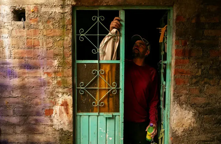 Rafael opens the door to his carpentry shop. In the United States, he worked up to three jobs to help pay for the family home in Zacatecas. Image by Erika Schultz. Mexico, 2019.
