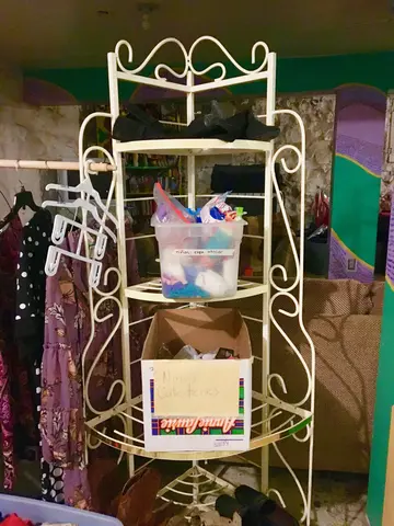 Volunteers at Casa Vides store donated clothing in the basement. After Border Patrol drops them off, new arrivals go downstairs to pick out a change of clothes. Bins labeled “niñas—ropa interior” and “Niñas Calcitenes [sic]” hold underwear and socks for children. Image by Lily Moore-Eissenberg. United States, 2019.