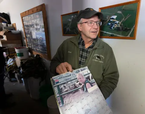 Paul Adams holds a calendar that featured his daughter, Becky, and their dairy herd.