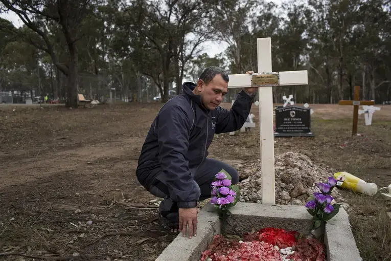 Vaea Togatuki, 48, visits the grave of his son, Junior, who died by suicide on September 11, 2015 while incarcerated in Goulburn's Correctional Center. Image by David Maurice Smith for The New York Times. Australia, 2018.