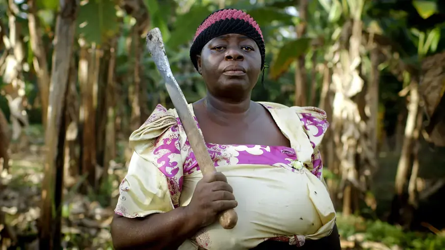 Betty Nanozi poses for a portrait in her fields. Betty, a widow for over a decade, first experienced property grabbing the moment she became a widow when her step children came into her home the night her husband died and took everything. Image by Amy Toensing and Kathryn Carlson. Uganda, 2016.