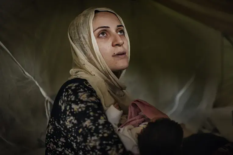 Taimma Abazli, 24, holds her new baby Heln in their tent at the Karamalis camp in Thessaloniki. Image by Lynsey Addario for TIME. Greece, September 2016.