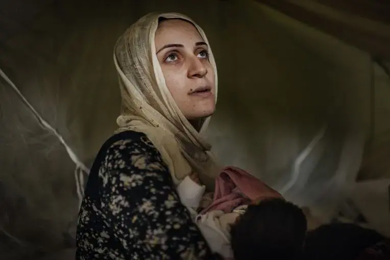 Taimaa Abazli, 24, holds her new baby Heln in their tent at the Karamalis camp in Thessaloniki. Image by Lynsey Addario for TIME. Greece, 2016.