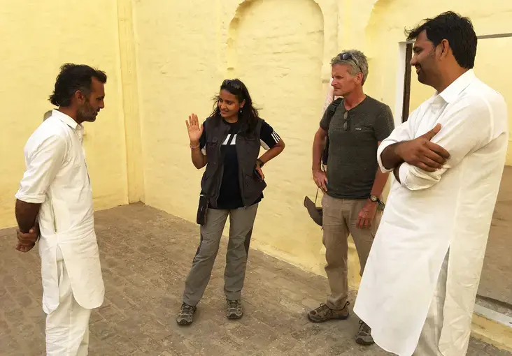 The owner of an old Muslim home, a rarity in this part of India, shows its distinctive layout to Arati Kumar-Rao, Paul Salopek and Sudhir Kukna. Image by Mark Schulte. India, 2018.