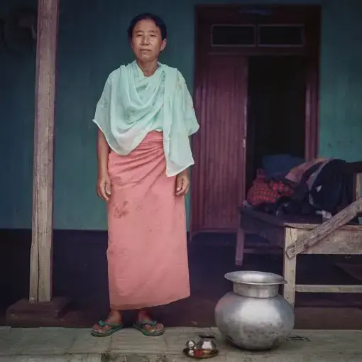 Muktarei Oinam, 54. Thanga Tongbram Leikai, Manipur For over two months Muktarei Oinam has been making numerous trips each day through her inundated yard to fetch water from the borewell. The flood destroyed her vegetable garden. Yards of numerous homes across the Loktak area remained flooded for weeks during monsoons not only destroying vegetable gardens and fishponds but also fruit-bearing trees. Experts believe that flooding in the region was an outcome of the Ithai Dam and climate change.