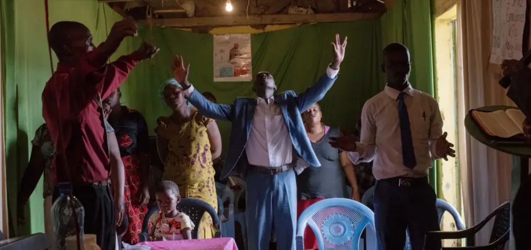 Worshippers inside Christ Miracle Church, originally built as a public toilet, in Kibera, Nairobi. Image by Peter DiCampo. Kenya, 2018.