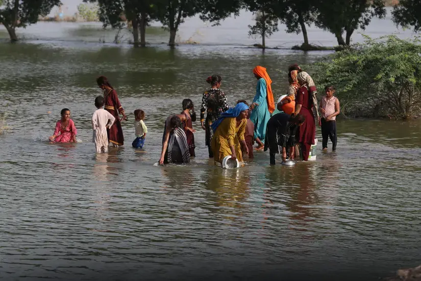 People wade through shin-high water