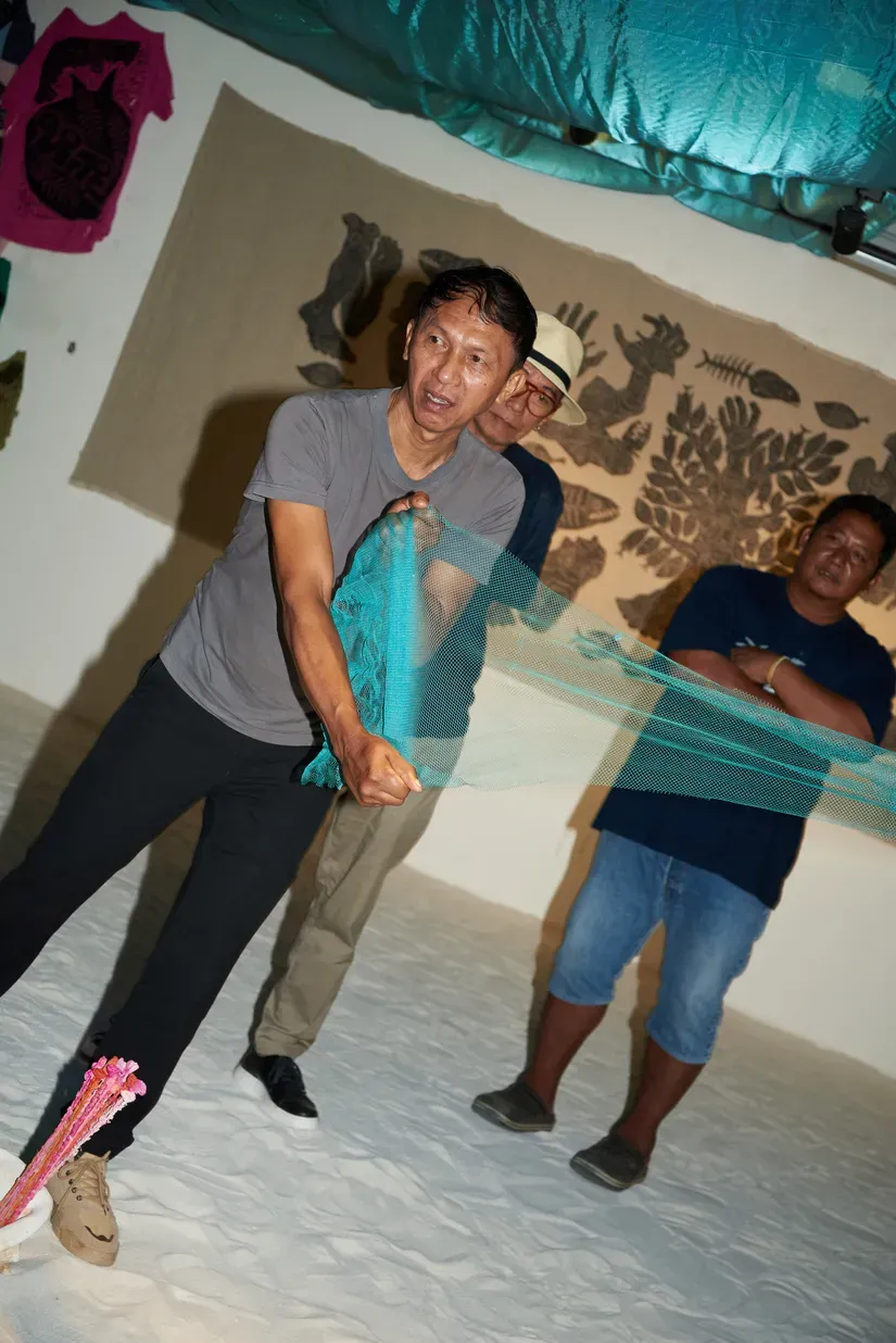 A fishing community representative present at the exhibition displays the fine-mesh net proposed in an amendment bill under parliamentary review—gear they fear would bring further devastation to the sea if passed