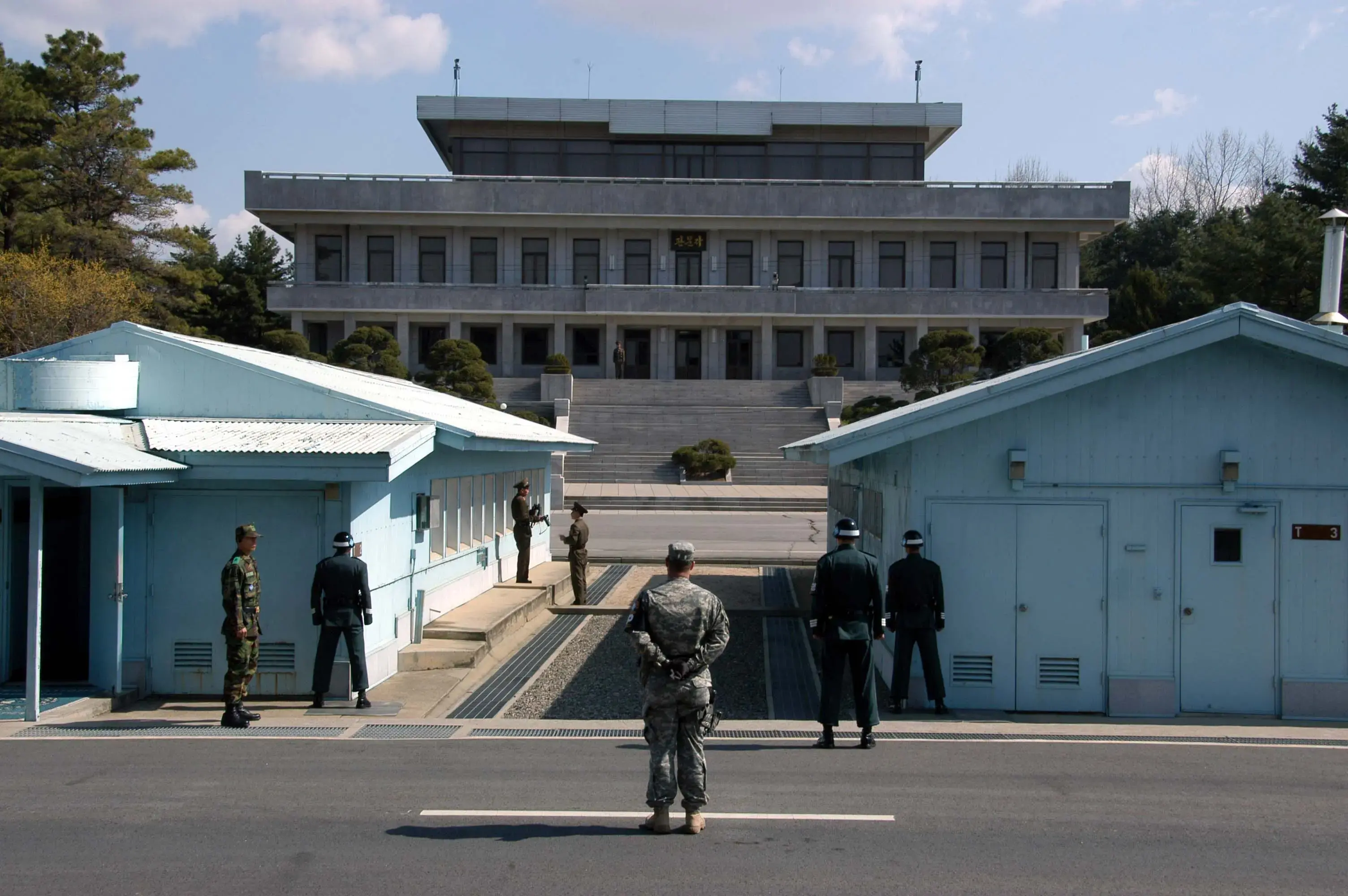 A view from South Korea towards North Korea in the Joint Security Area at Panmunjom. North and South Korean military personnel, as well as a single US soldier, are shown. Image by user: Driedprawns/Wikimedia Commons. South Korea, 2007. A view from South Korea towards North Korea in the Joint Security Area at Panmunjom. North and South Korean military personnel, as well as a single US soldier, are shown. Image by user: Driedprawns/Wikimedia Commons. South Korea, 2007.
