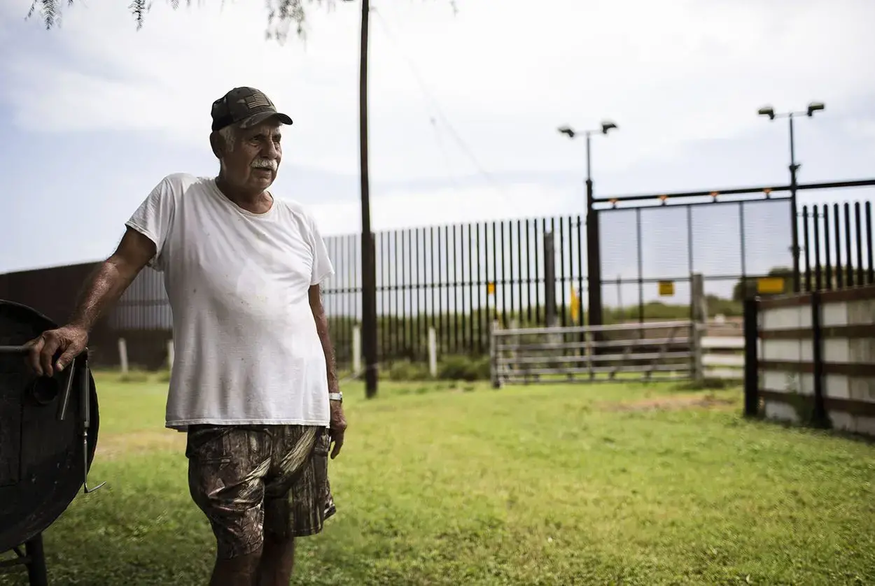 Juan Cavazos at his home on Oklahoma Avenue in Brownsville, Texas. The federal government took part of the former teacher's land to build the border fence. Image by Martin do Nascimento. United States, 2017. Juan Cavazos at his home on Oklahoma Avenue in Brownsville, Texas. The federal government took part of the former teacher's land to build the border fence. Image by Martin do Nascimento. United States, 2017.