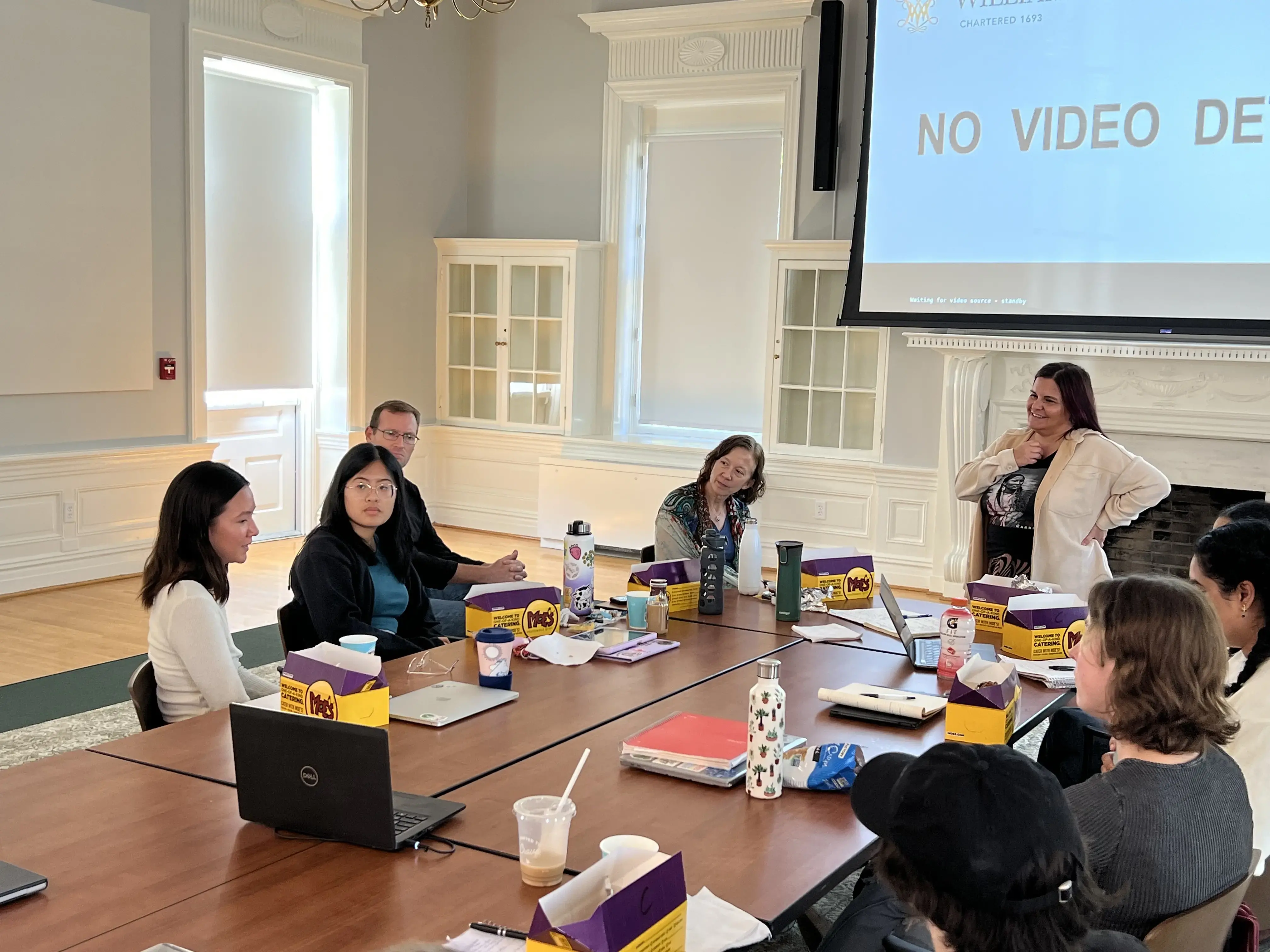 Journalists and students talk around a classroom table