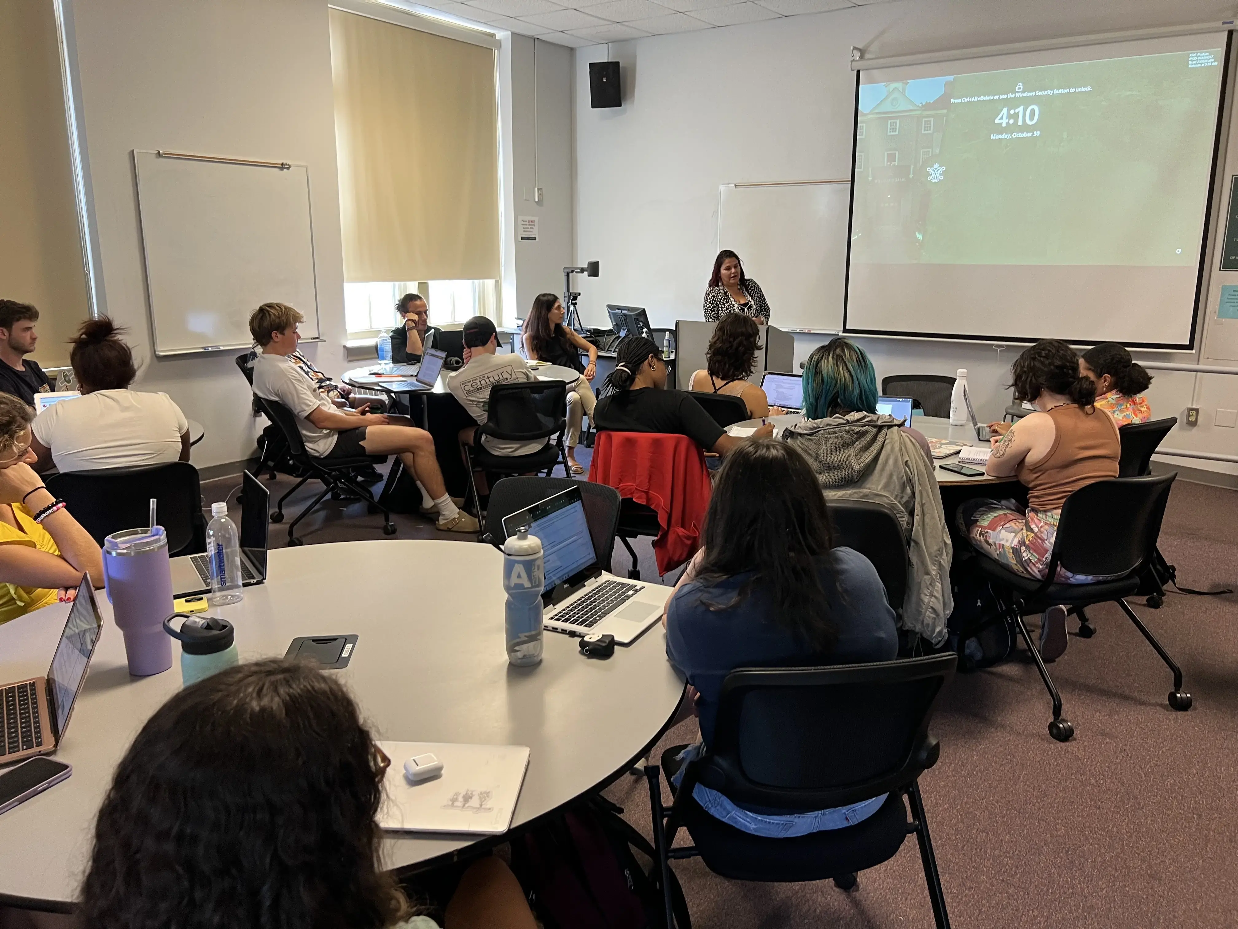 Students listen to journalists speak in a classroom