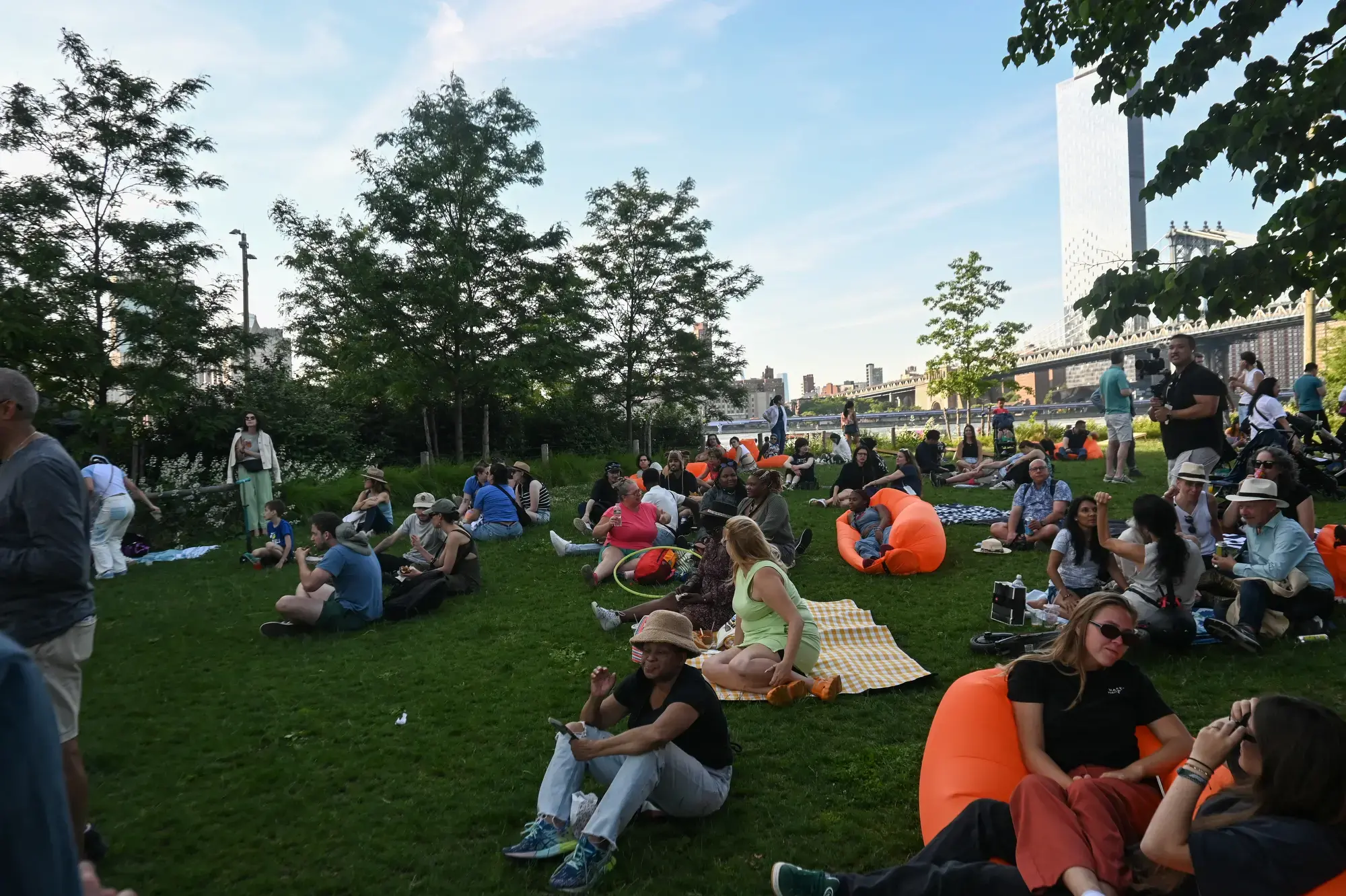 Festival attendees mingle at the Photoville beer garden during opening weekend in Brooklyn Bridge Park. Image by Grace Jensen. United States, 2024.