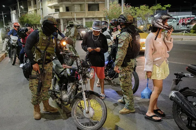 soldiers stop motorcycle at vehicle checkpoint