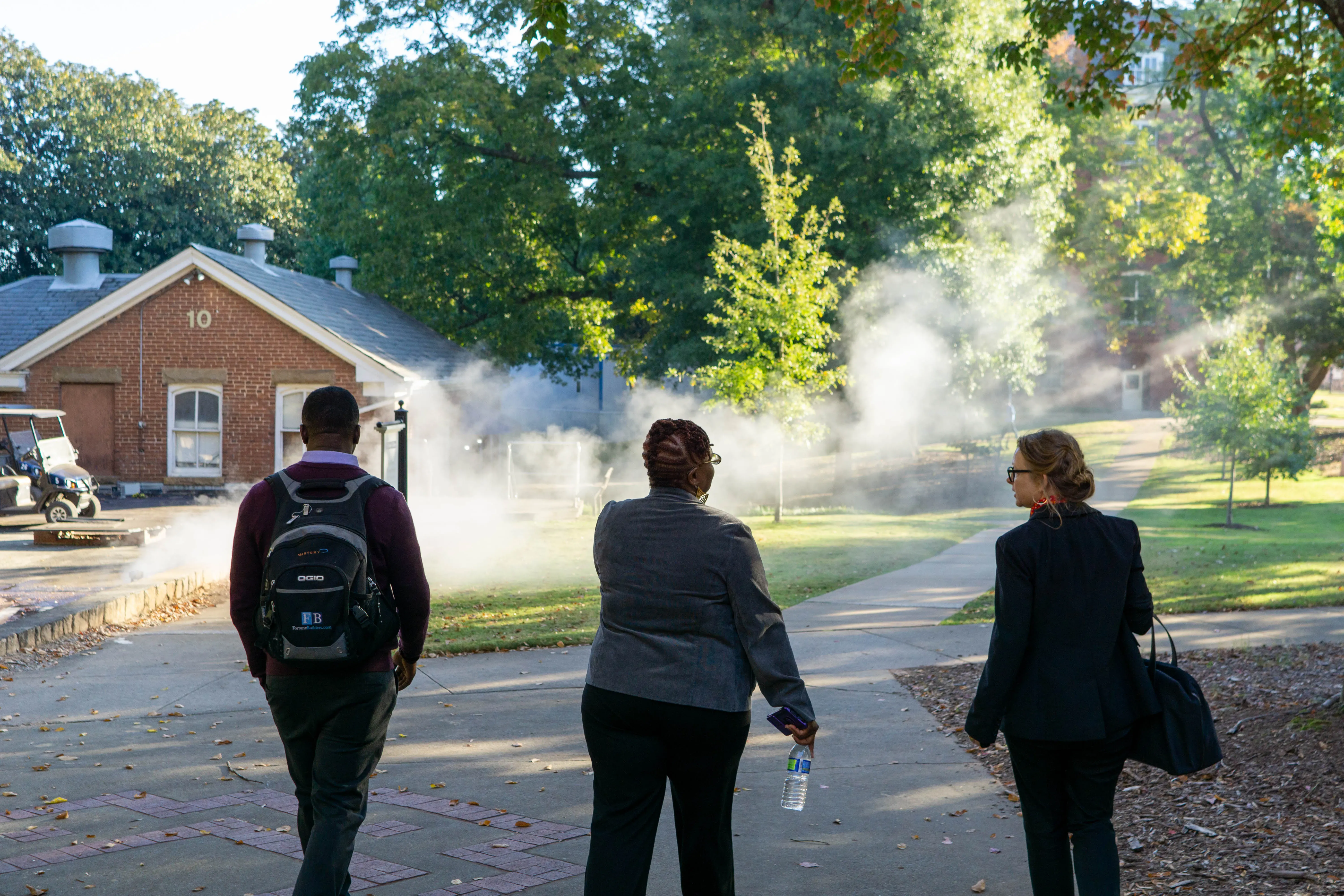 Three people walk away from camera