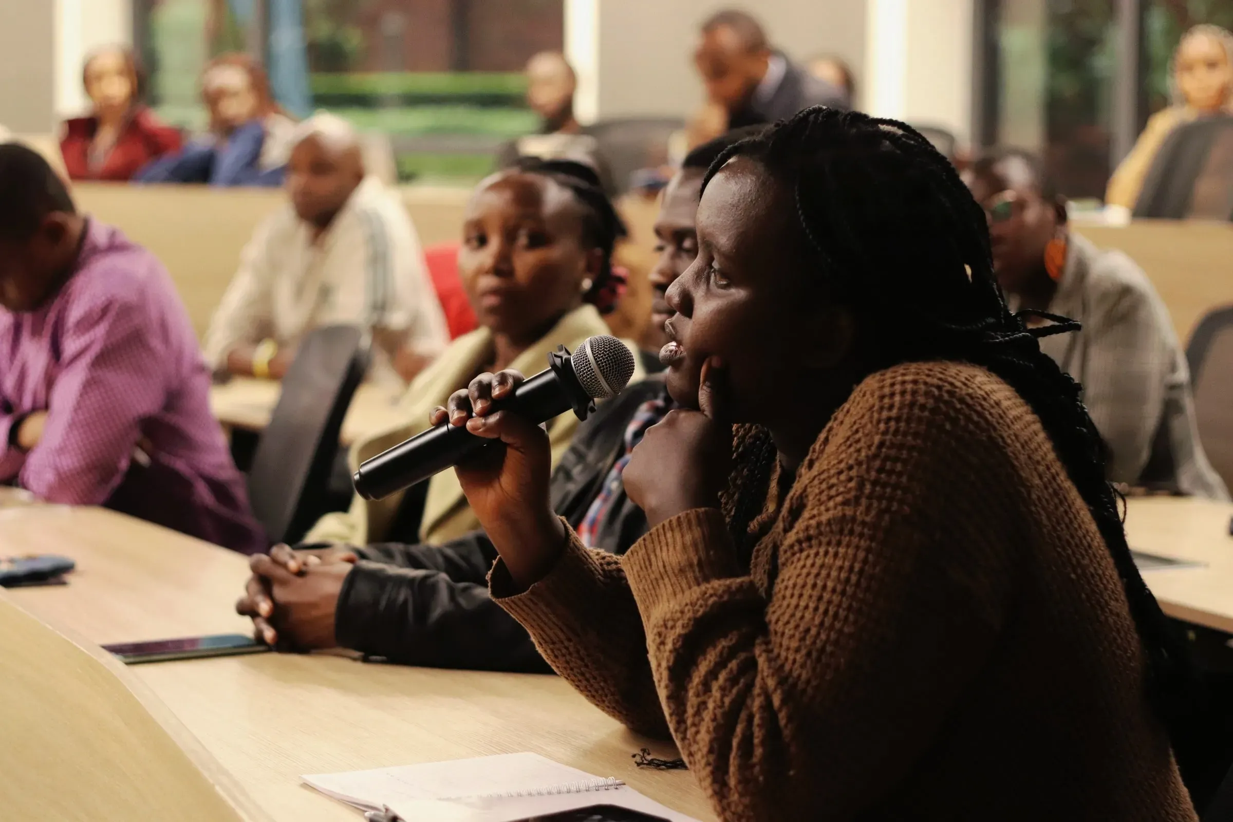 a woman speaks in a microphone at a townhall event