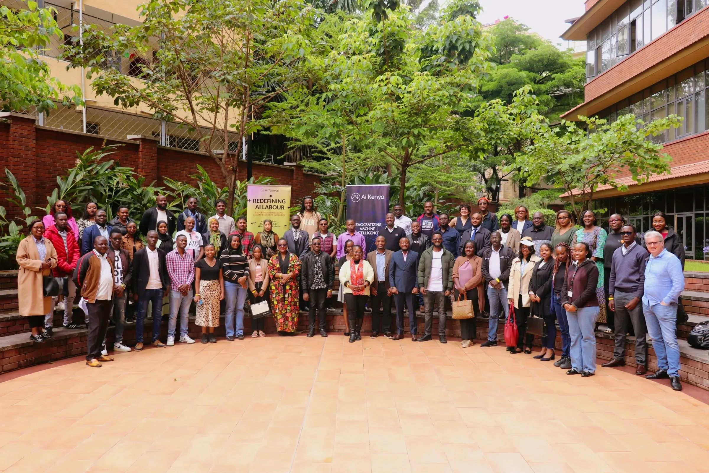 Group photo of participants, panelists and organizers of the event outside with trees in the background
