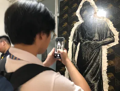 student takes a photo of art