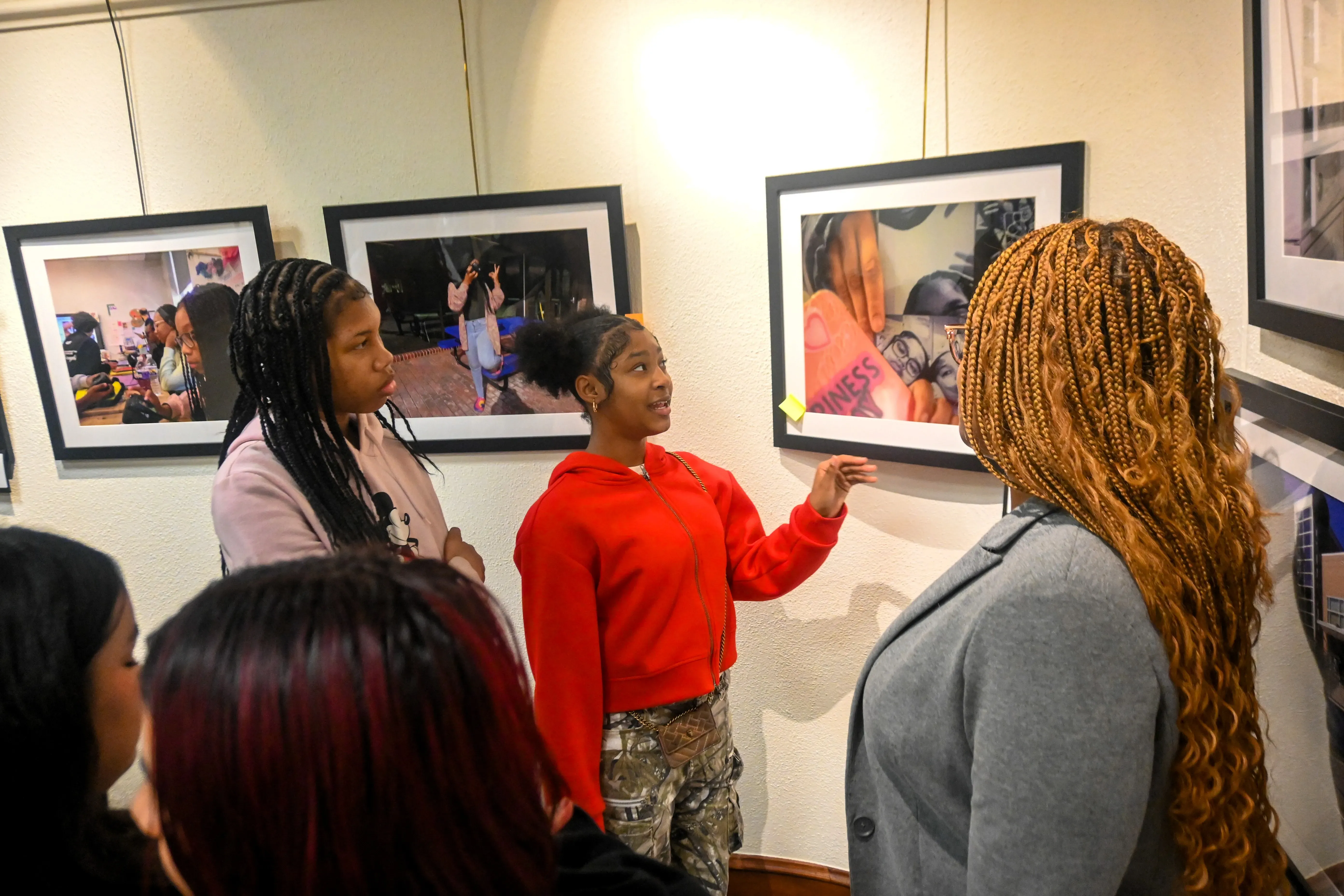 young people gather around a printed photograph at an exhibit