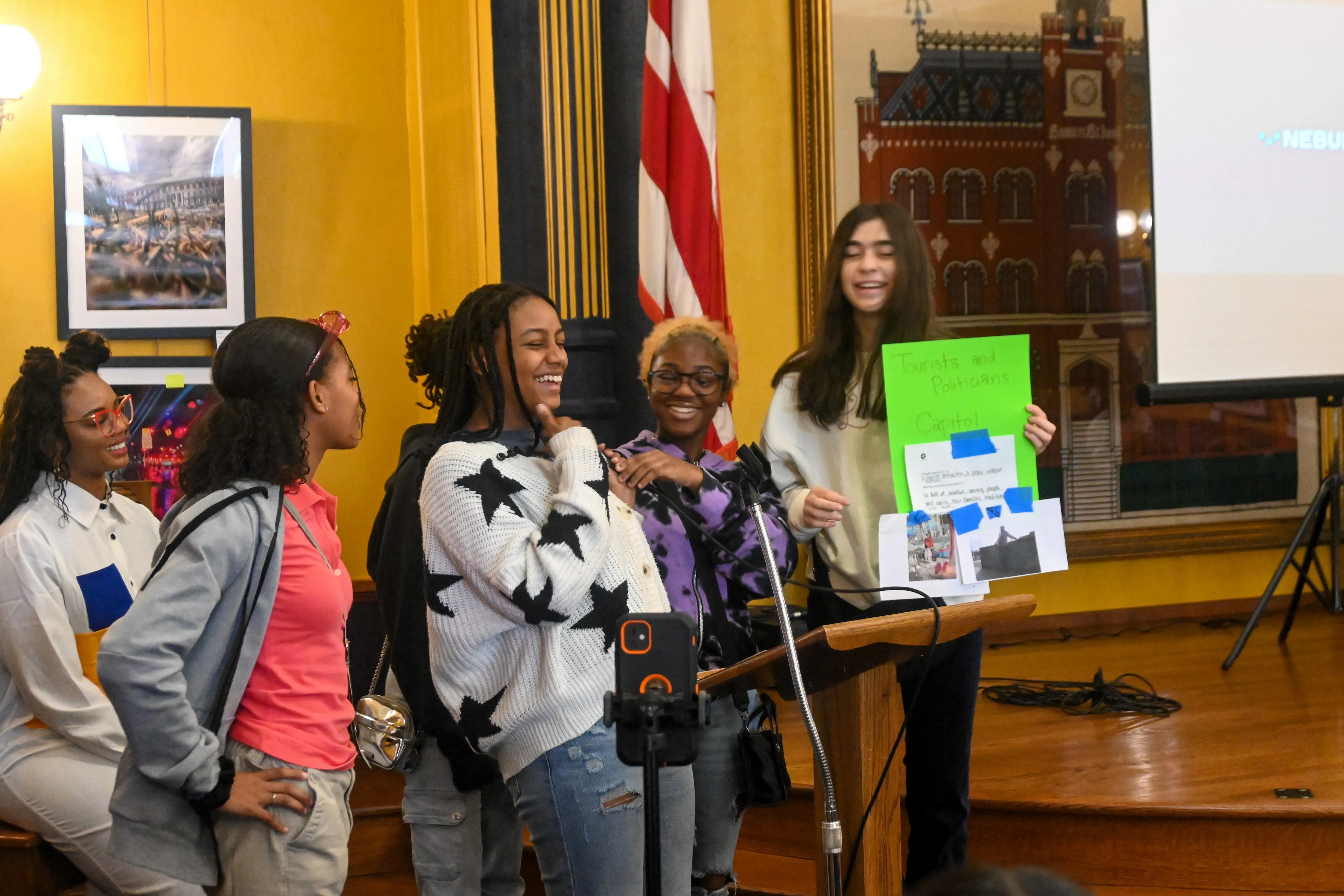 Students present in a group at a podium