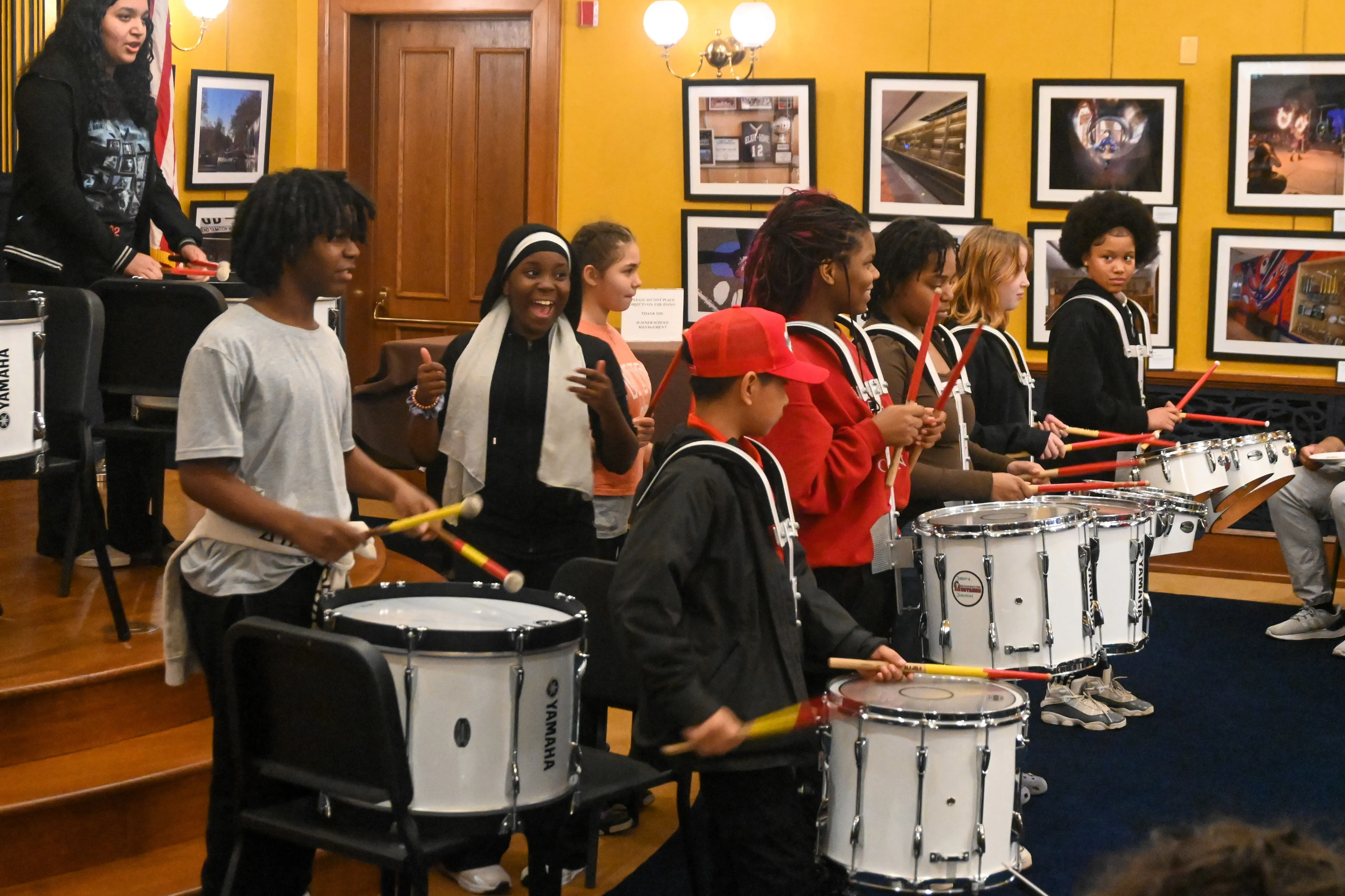 Student drummers perform on a small stage