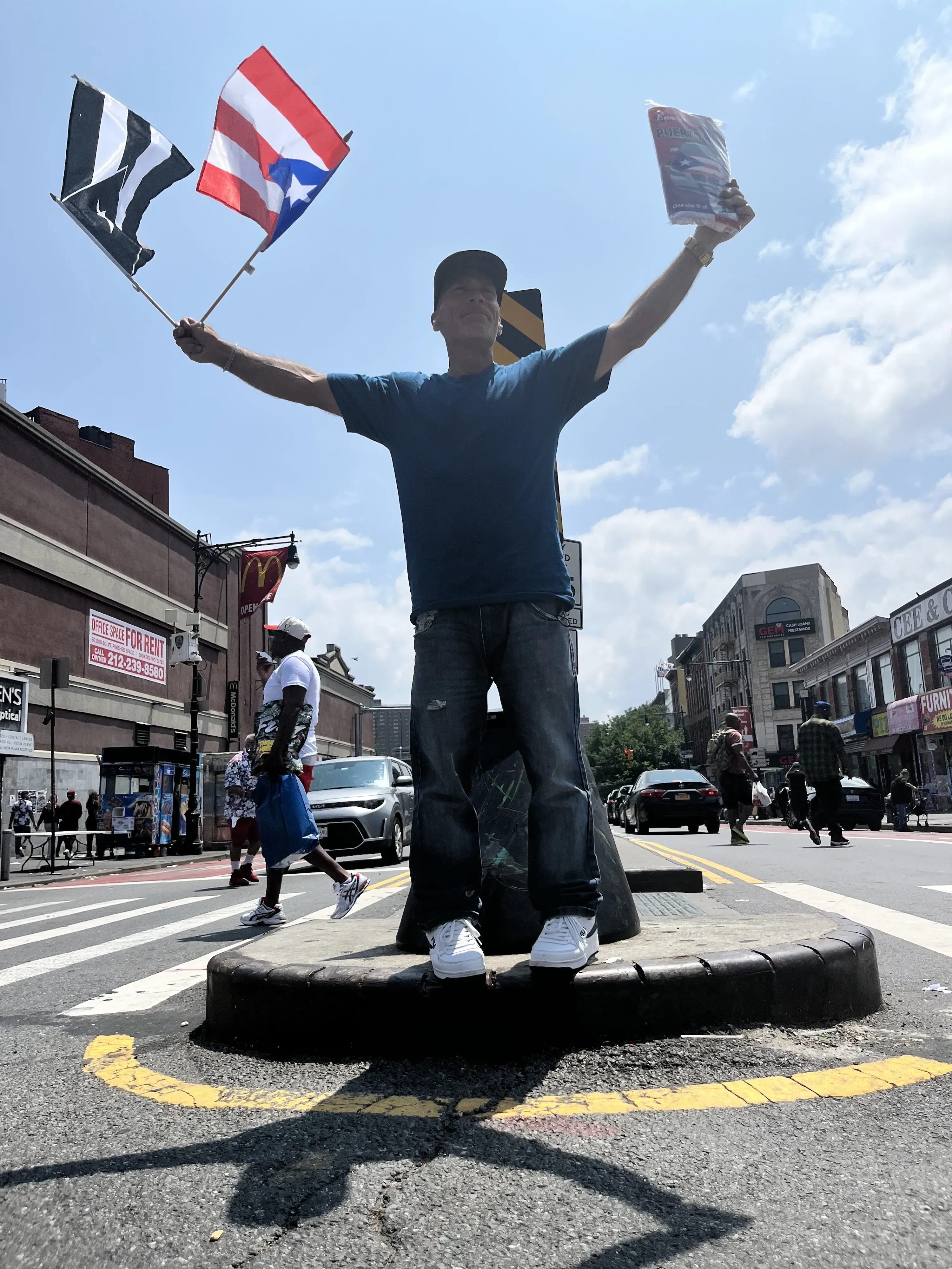 Man holds two flags in street median