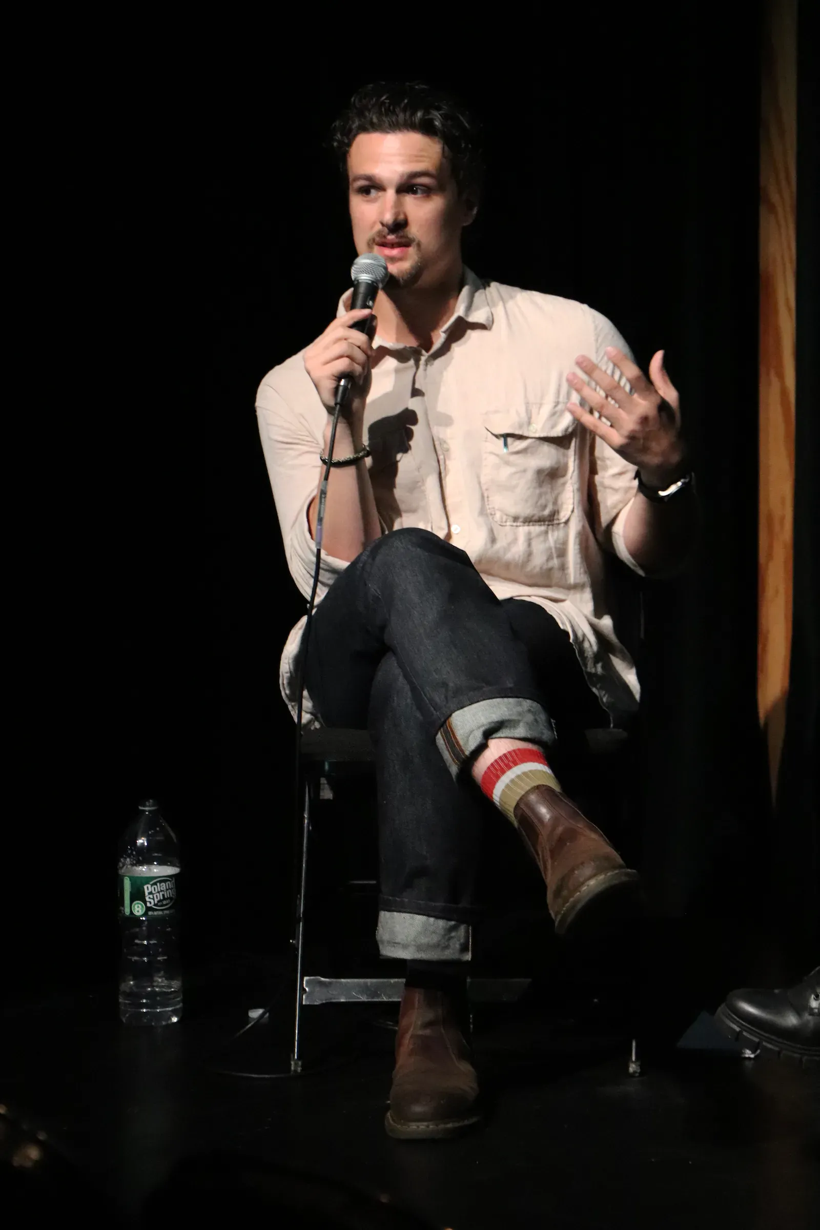 Man in white button up shirt speaks into microphone