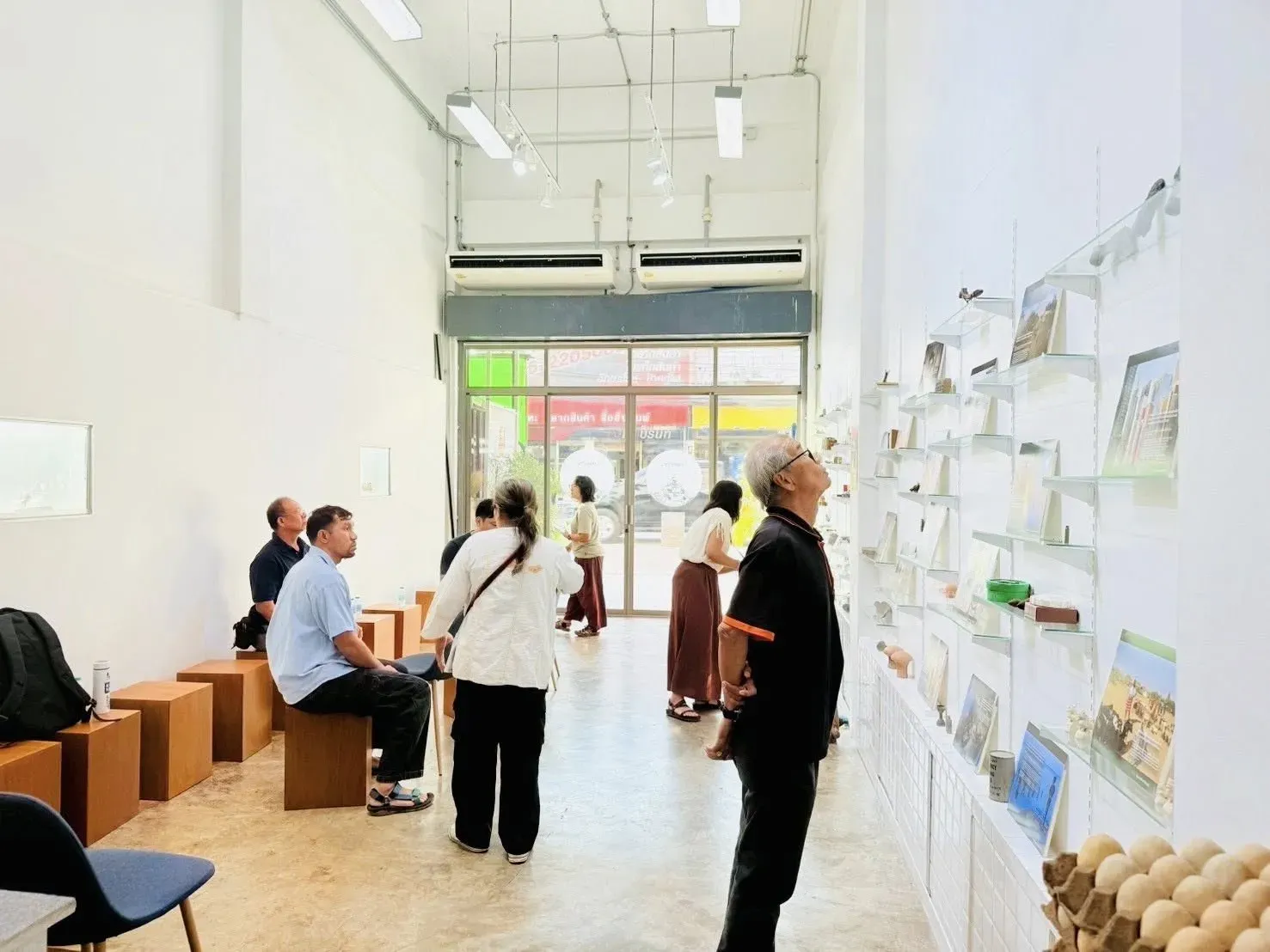 Participants view a mini photo exhibition from the Pulitzer Center-supported reporting on work and environment. Photo credit: Chanlika Thipfun