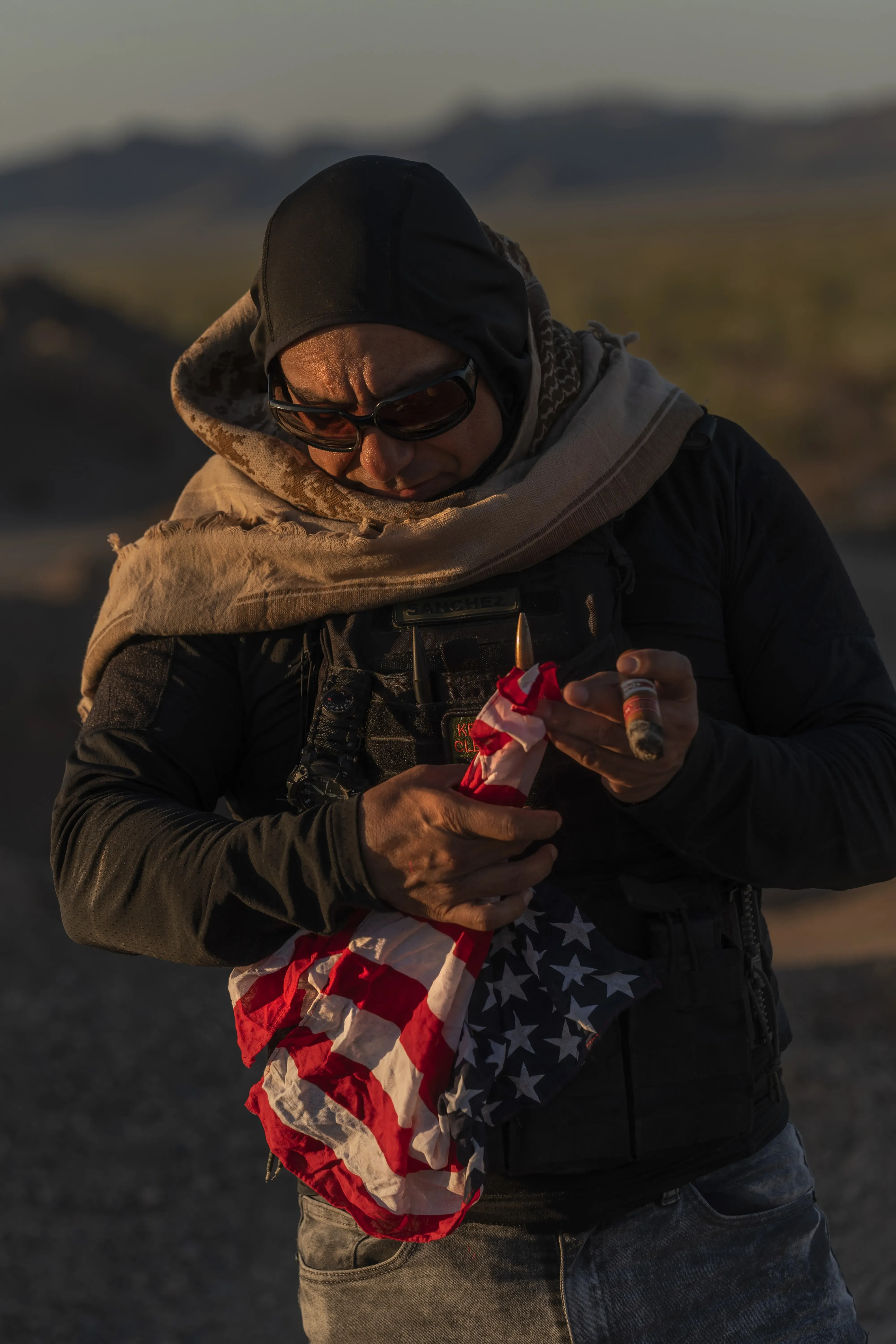 Alejandro Sánchez, at La Ciénega in June, sometimes carries a U.S. flag to remind people he is an American. He was hired to help reclaim the gold mine from a cartel. (Félix Márquez / For The Times)