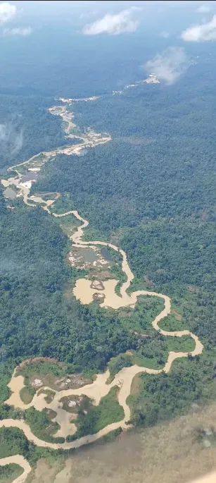 Aerial helicopter photo: A winding river shows pools of muddy water along its banks