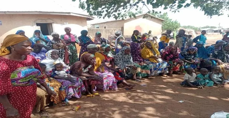 Children and women gather in an outdoor setting