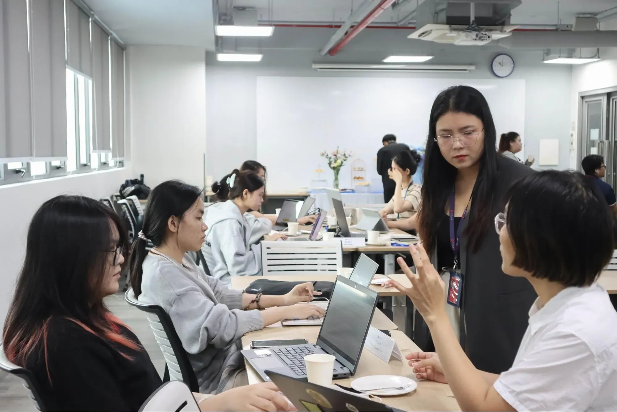 Students discussing their op ed drafts with lecturer and journalist Bao Uyen, Image by Huynh Tan Loi. Vietnam, 2026.