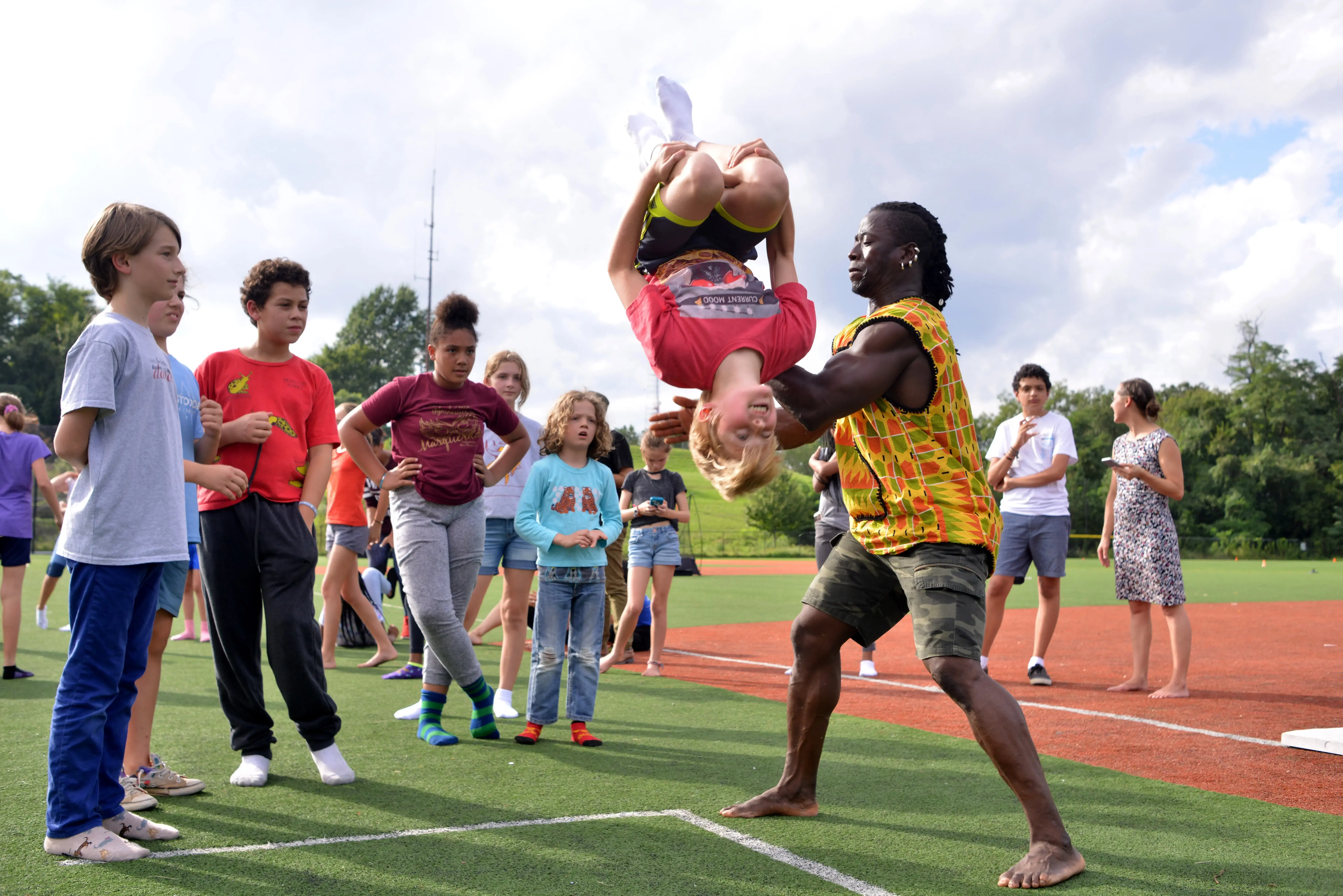 With help from Yamoussa, a Deal Middle School student completes a backflip. Image by Dermot Tatlow. United States, 2018.