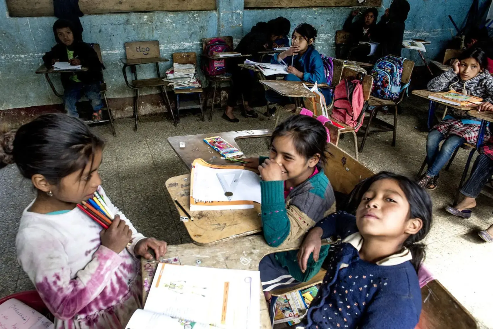 An empty desk where Baldemar Lucas García Alonzo once sat sits against the wall at the primary school in Bulej, Guatemala. Baldemar left with his father the previous week for the U.S. Image by  Simone Dalmasso / The Arizona Daily Star. Guatemala, 2019.