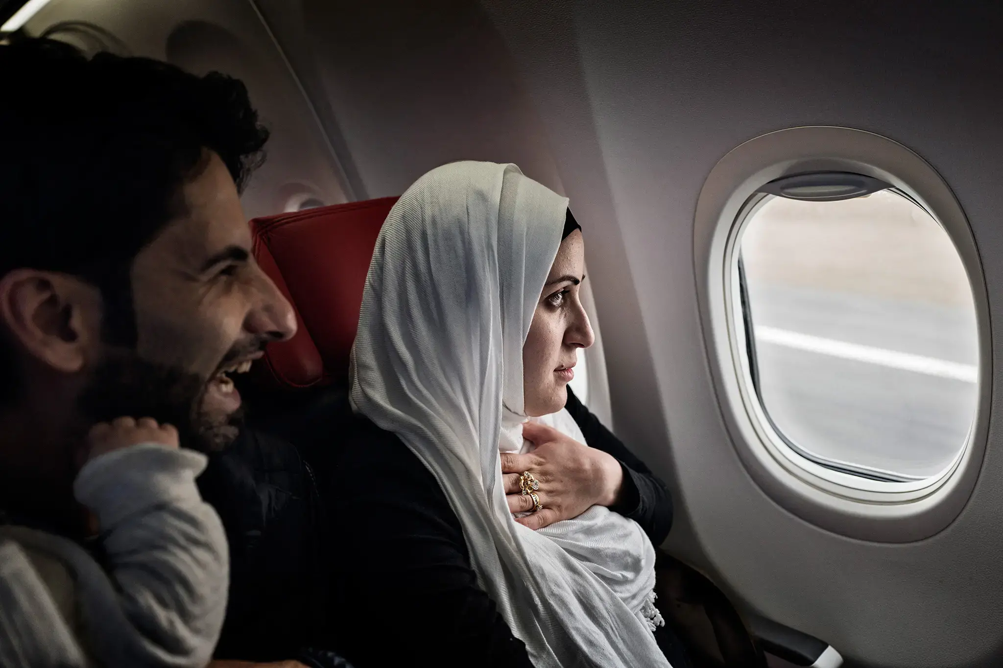 Syrian refugees Taimaa Abzali and her husband Muhanned Abzali, look out the window with a mix of fear and excitement as they see Estonia from the air for the first time. Image by Lynsey Addario. Estonia, 2017. Syrian refugees Taimaa Abzali and her husband Muhanned Abzali, look out the window with a mix of fear and excitement as they see Estonia from the air for the first time. Image by Lynsey Addario. Estonia, 2017.