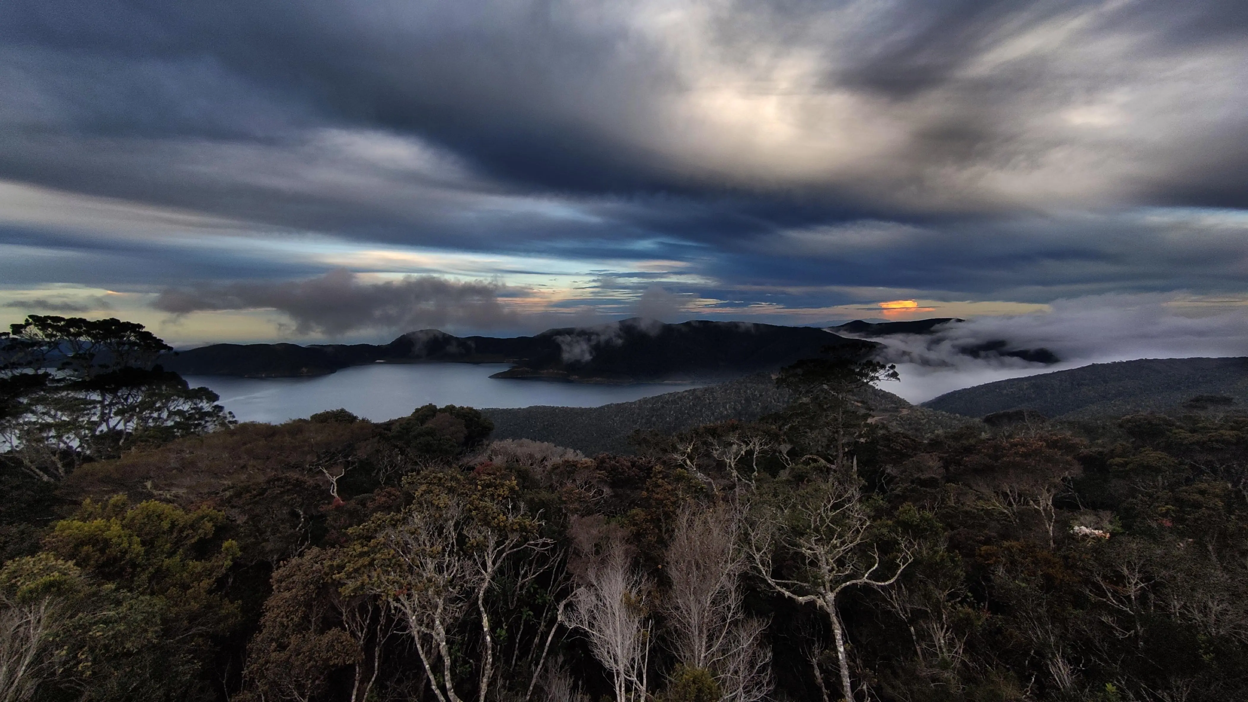 Sunset over the rainforest, lakes, and mountains seen from above in West Papua, Indonesia.